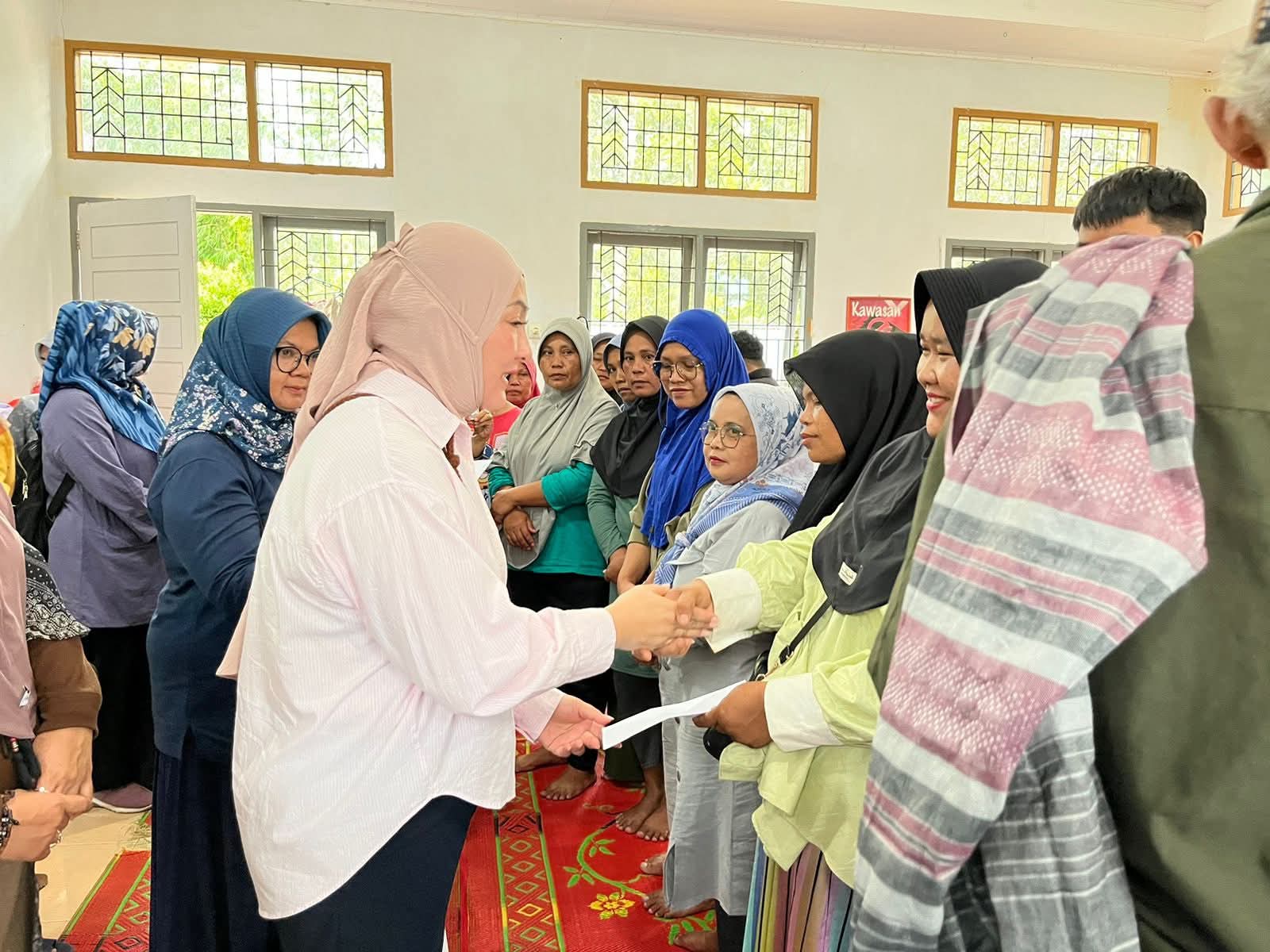 Ketua TP PKK Padang Panjang, Maria Feronica Hendri saat salami para pengungsi